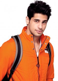 a young man in an orange jacket is posing for the camera with a backpack on his back