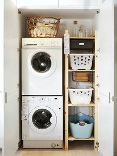 a washer and dryer are stacked in a small closet with baskets on the shelves