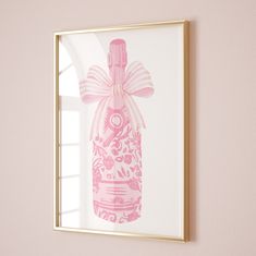 a pink bottle is hanging on the wall next to a window with a gold frame