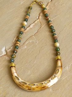 "Selena" is an addition to our Wanderlust collection. Green agate, jade, coconut shell and gold spacer beads with brass accented bone horn. Bohemian style necklace is approximately 22" in length and perfect for layering with long necklaces. Coordinating bracelets sold separately. With every purchase, a donation is made to plant a tree through our partnership with One Tree Planted. Agate Necklaces, Wooden Bead Jewelry, Bone Horn, Horn Necklace, Horn Pendant, Long Necklaces, Necklace Green, Beaded Statement Necklace, Green Agate