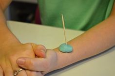 a person holding something in their hand with a toothpick sticking out of it