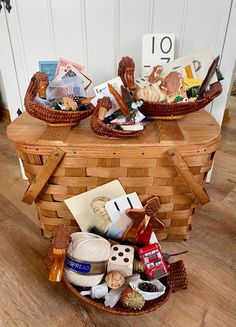 two wicker baskets filled with items on top of a wooden floor