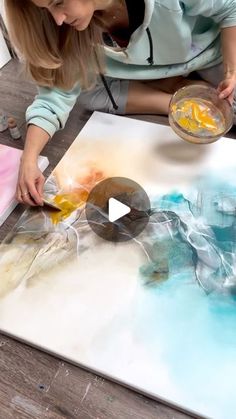 a woman is working on an art project with acrylic paint and watercolors