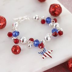 an american flag charm bracelet with red, white and blue bead charms on it