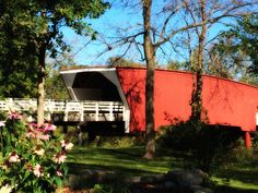 a red covered bridge over a lush green park