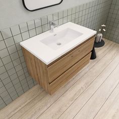 a white sink sitting next to a mirror in a bathroom on top of a wooden floor