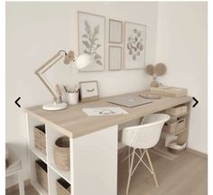 a desk with two chairs and a laptop on top of it in front of a white wall