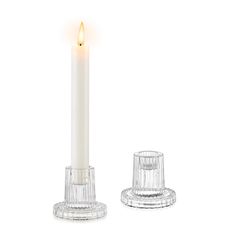 a white candle sitting on top of a glass holder