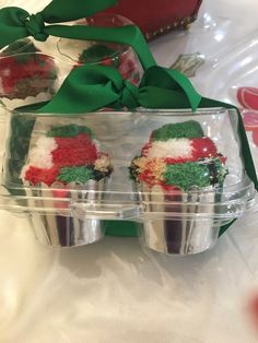 three cupcakes in plastic containers with green bows