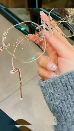 a woman holding onto some kind of glasses with pearls on it's rims