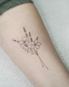 a small flower tattoo on the arm