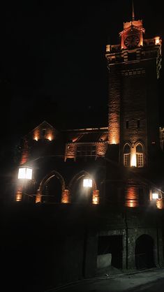 an old building lit up with lights at night