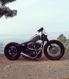 a black motorcycle parked on top of a hill