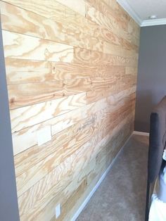 a bedroom with wood paneling on the wall and a chair in front of it