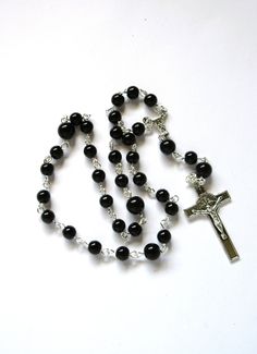 This black Anglican rosary is made with 6 and 8mm black round crystal beads. The crucifix is pewter. I hand turned the silver plated wires. It is also suitable for Protestant, Episcopal, and Methodist prayer. It measures 15 inches around with a 3.5 inch cross drop. The larger beads are black glass. This rosary will be slipped into a velvet bag and shipped in a bubble mailer. Black Rosary, Anglican Rosary, Bubble Mailer, Velvet Bag, Prayer Beads, Black Crystals, Black Glass, Rosary, Round Glass