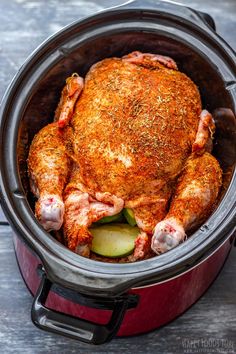 a whole chicken in a crock pot with some garnish on the side