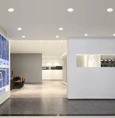 an empty room with white walls and lights on the ceiling is lit by recessed lighting