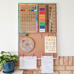 a bulletin board on the wall next to a potted plant