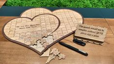 a wooden puzzle heart with two pieces cut out to look like it has been placed on a table