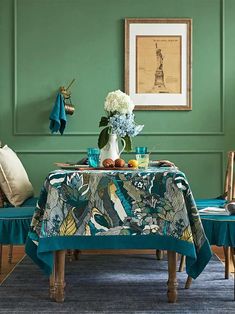 a dining room with green walls and blue table cloth