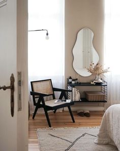 a bedroom with a bed, mirror and chair