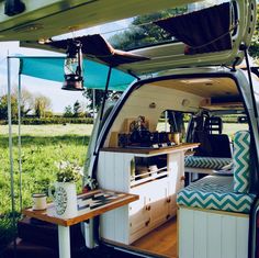 the interior of a camper van with its door open and table in the back