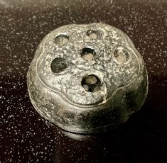 an old metal object sitting on top of a table