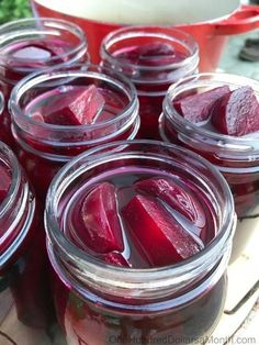 jars filled with beets sitting on top of a table