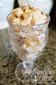 a glass bowl filled with nuts on top of a counter