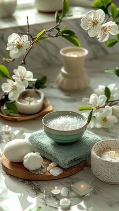 a table topped with white flowers and bowls filled with liquid on top of each other