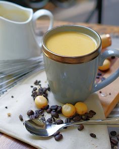 a cup of coffee and some beans on a table