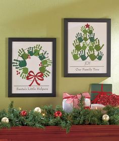 two christmas pictures hanging on the wall above a mantel decorated with greenery and handprints