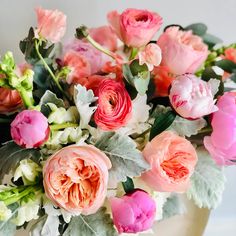 a vase filled with lots of pink and white flowers