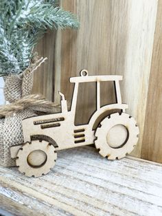 a wooden tractor ornament sitting on top of a table next to a christmas tree