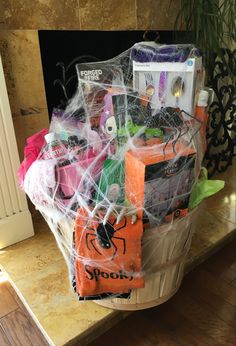 a basket filled with halloween items sitting on top of a counter next to a fireplace