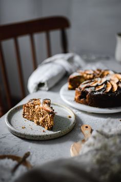 two plates with slices of cake on them sitting on a table next to each other