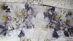 an abstract painting with yellow and black flowers on white paper, hanging on a wall