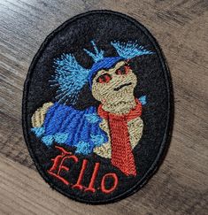 an embroidered patch with the word elo on it and a cartoon character wearing a red scarf