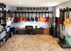 guitars and amps are hanging on the wall in this music room with carpeted flooring