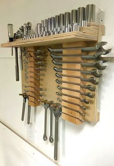 there are many different tools hanging on the wall with each one's own wrench holder