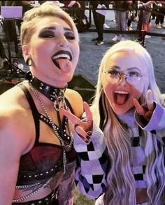 two women dressed in costume posing for the camera with their mouths open and tongue out