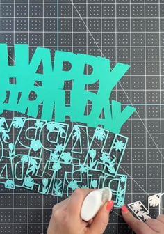 someone is cutting out the happy birthday card