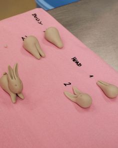 there are five small plastic animals on the pink sheet that is made to look like teeth