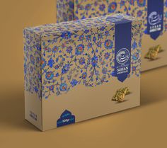 two boxes with blue and yellow designs on the front, one has gold flakes in it