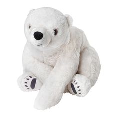 a white teddy bear sitting on the ground