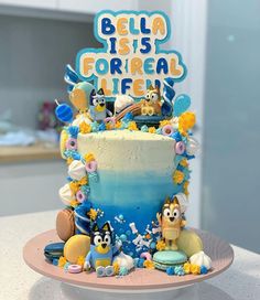 a birthday cake decorated with cartoon characters on it's side and the words bella ists correal life