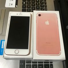 two iphones are sitting next to each other in front of a laptop computer on a desk