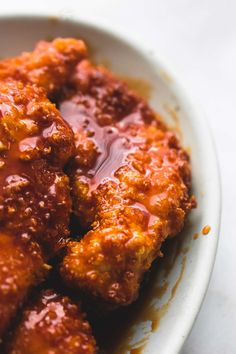 a white bowl filled with meat covered in sauce