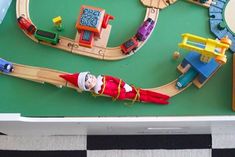 a toy train set with santa clause on it and other toys in the box next to it