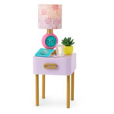 an alarm clock sitting on top of a table next to a potted plant and a lamp